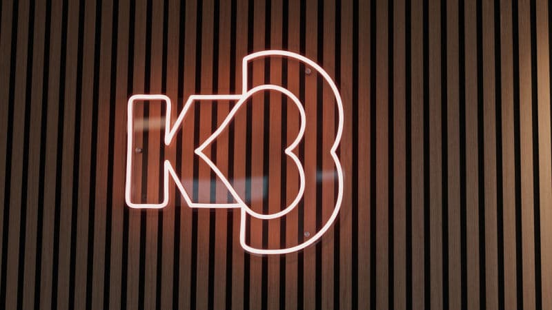 K3's logo in neon on a wood-panelled wall